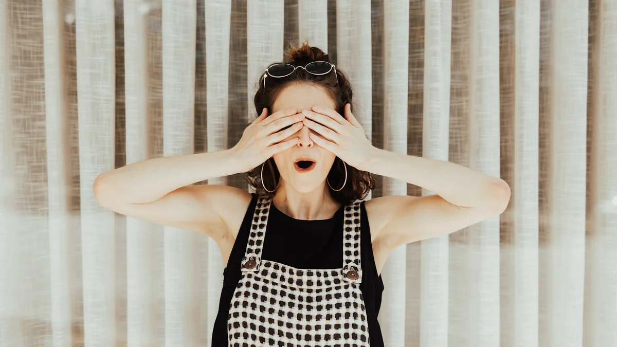 woman covering eyes with hand Ilustração editorial secção 2 sobre como escolher cortina e persiana no formato paisagem