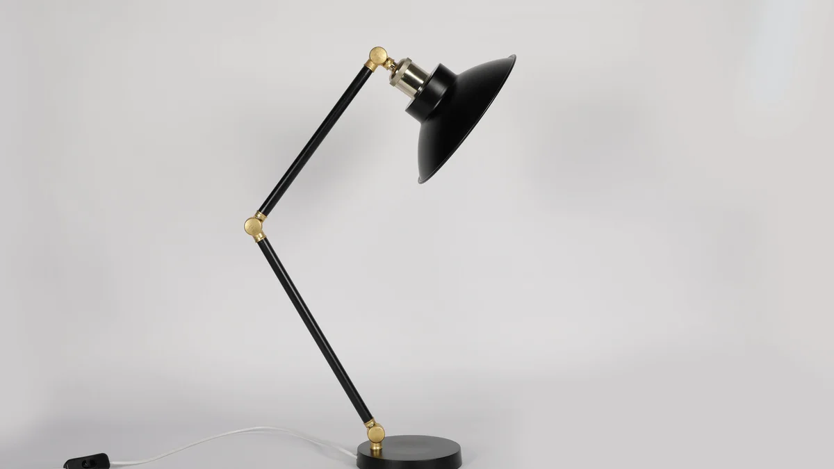 Luminária de mesa preta elegante e ajustável, sobre fundo branco, com design moderno.