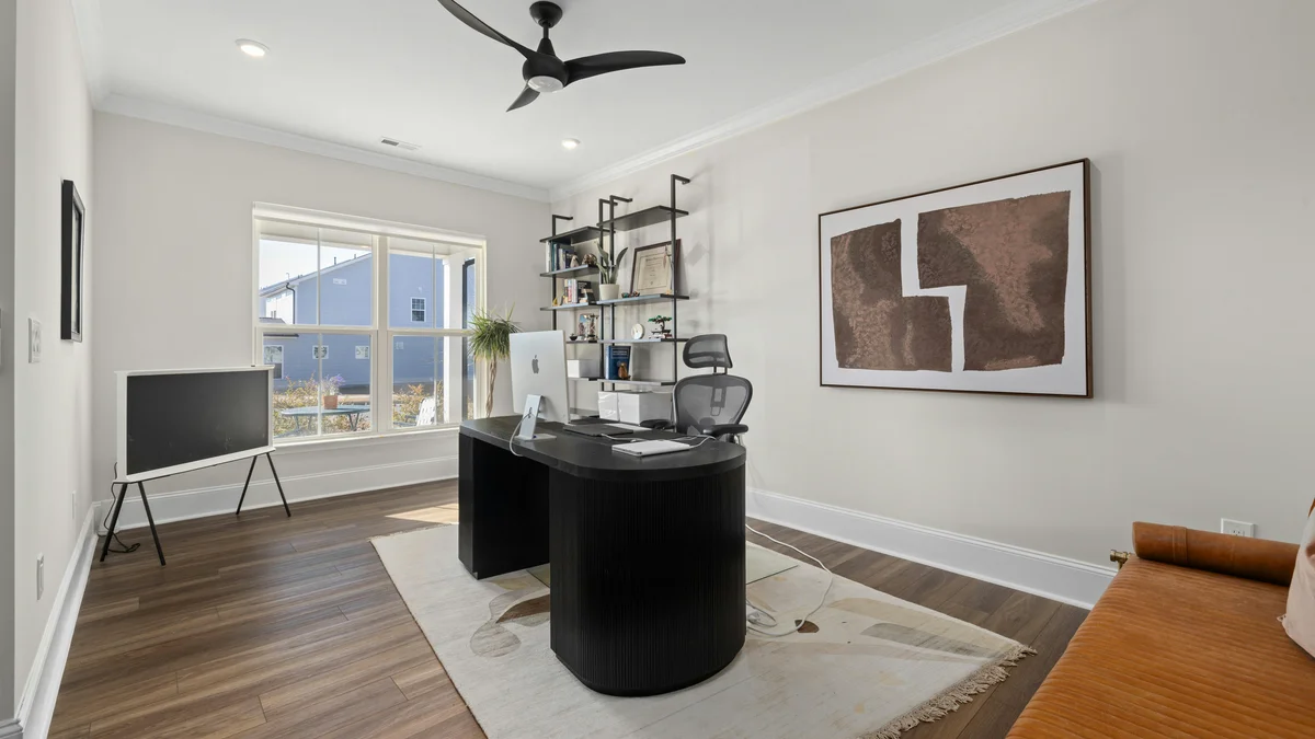 Escritório moderno e elegante em casa com mesa sofisticada, obras de arte e muita luz natural, criando um ambiente de trabalho inspirador.