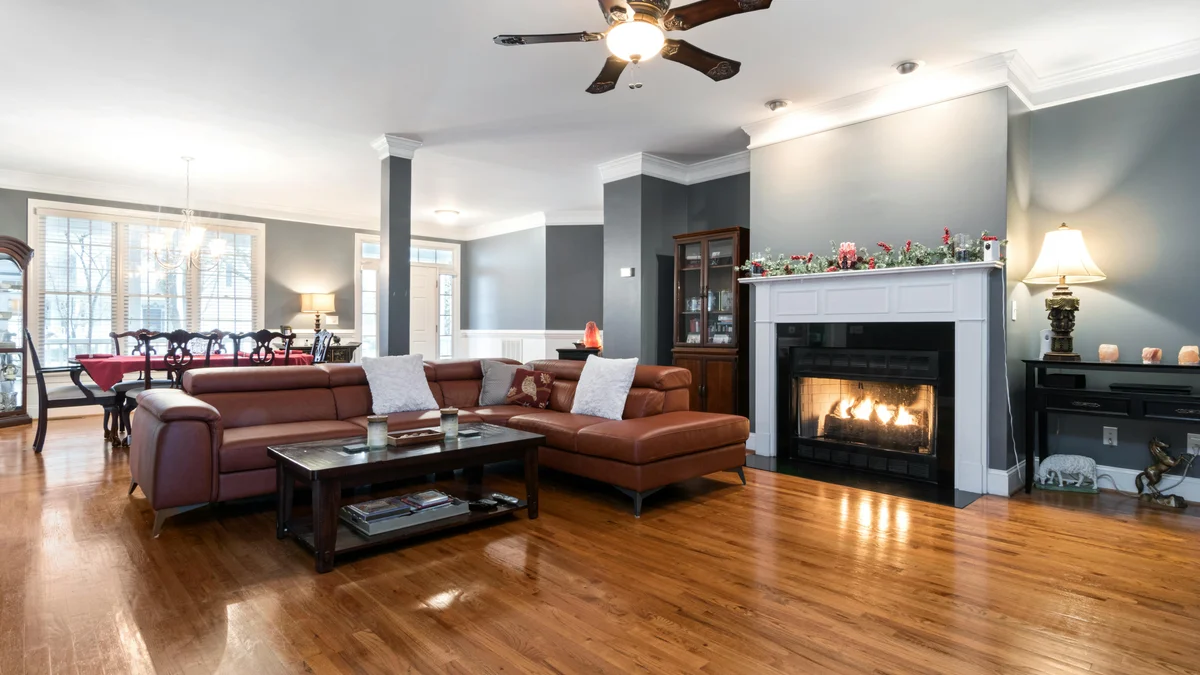 Ampla sala de estar com lareira aconchegante e elegante piso de madeira, perfeita para conforto e estilo.