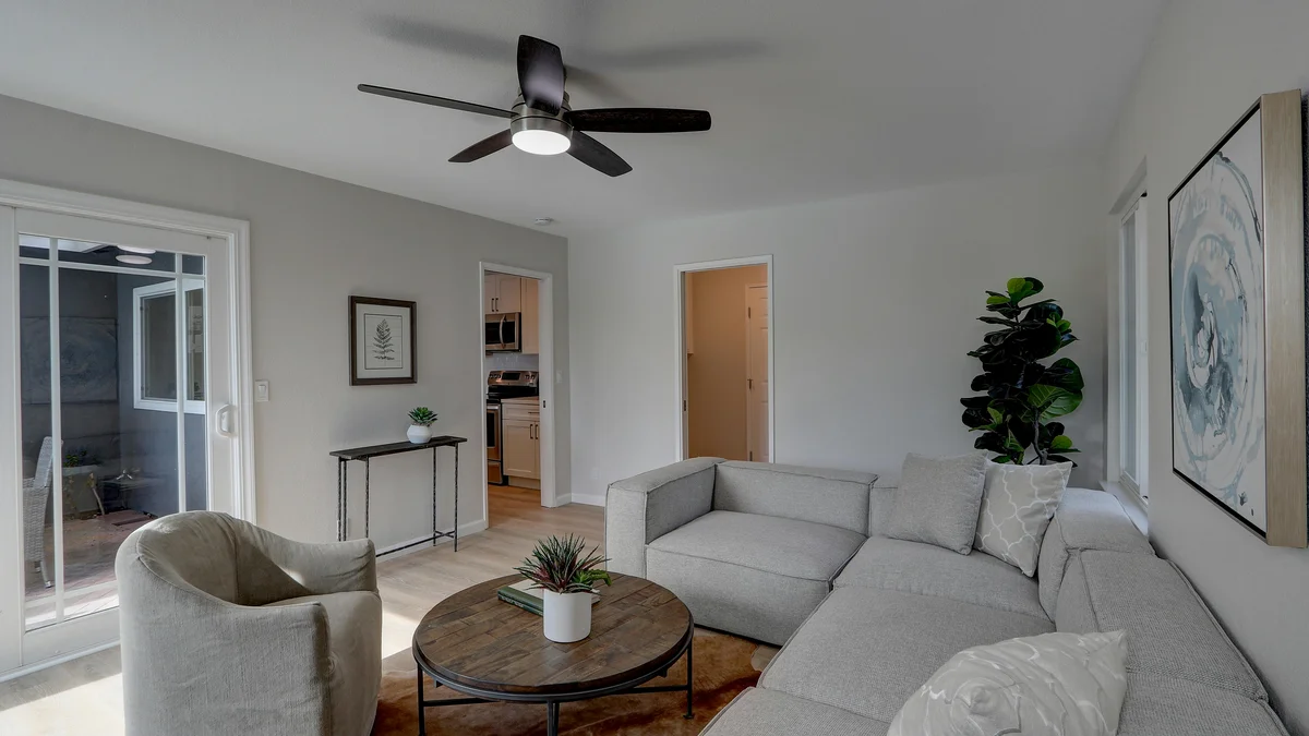 Interior de sala de estar elegante com mobiliário moderno e tons neutros, transmitindo sofisticação e conforto.