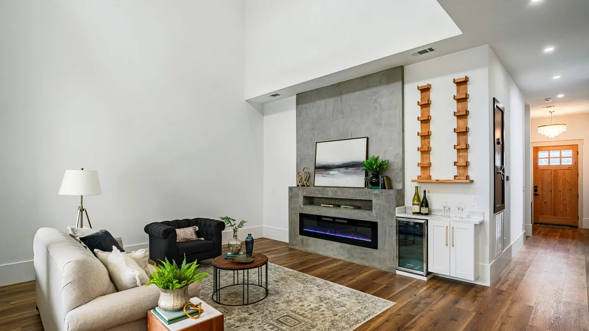 Sala de estar sofisticada com decoração contemporânea e lareira em uma casa em Nova Orleans, criando um ambiente acolhedor.