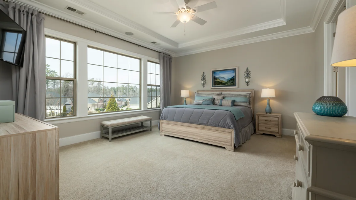 Quarto contemporâneo com grandes janelas, decoração neutra e elegante, criando uma atmosfera acolhedora e iluminada.