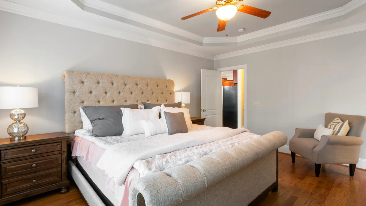 Quarto moderno com decoração sofisticada, cama confortável e iluminação elegante, proporcionando um ambiente convidativo.